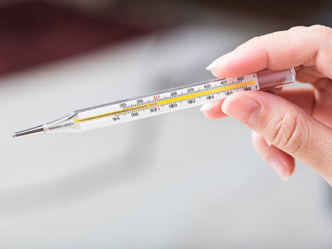 Close-up hand holding on thermometer for checking patient.